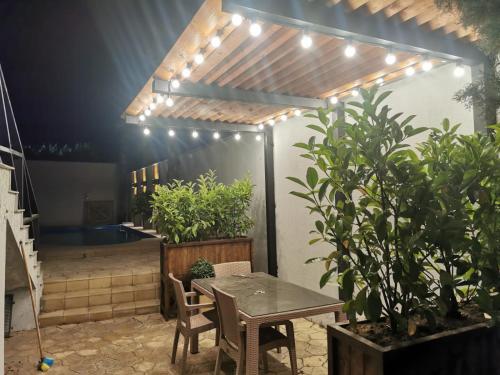 a patio with a table and some plants and lights at Sunnyside Bilgah villa 2 in Baku