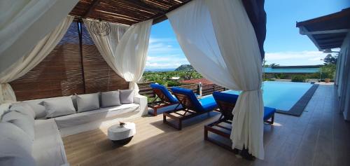 een woonkamer met een witte bank en blauwe stoelen bij Villa Vintana Nosy Be in Nosy Be