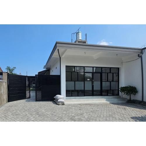 a white house with a large garage at Guest House Saqeena Syariah Near Blitar Park RedPartner in Blitar