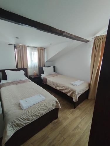 a bedroom with two beds and a window at Къща за гости - Вила Сидона in Banya