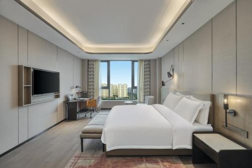 a hotel room with a large bed and a television at Crowne Plaza Lanzhou New Area by IHG in Lanzhou