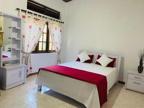 a bedroom with a bed and a window with curtains at Mountain Breeze Uplands in Kandy