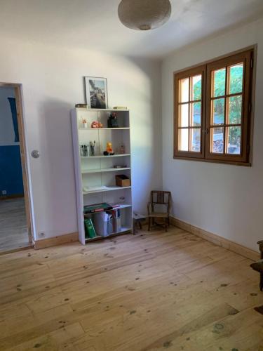 une chambre avec une étagère et une fenêtre dans l'établissement Au coeur des arbres, à Dieulefit