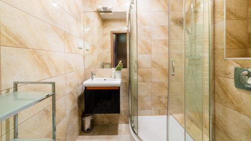 a bathroom with a shower and a sink at VacationClub - Leśny Dom 18 Apartament 15 in Karpacz