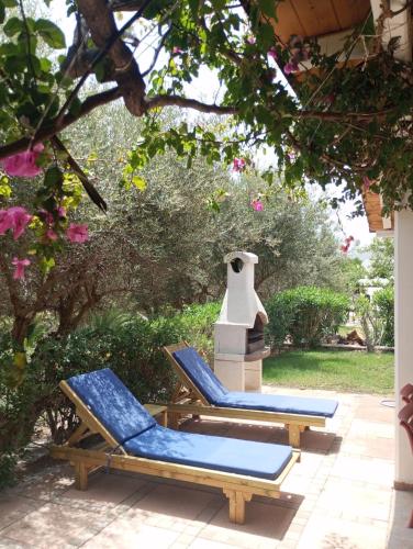 two lounge chairs on a patio under a tree at Valley Village in Matala