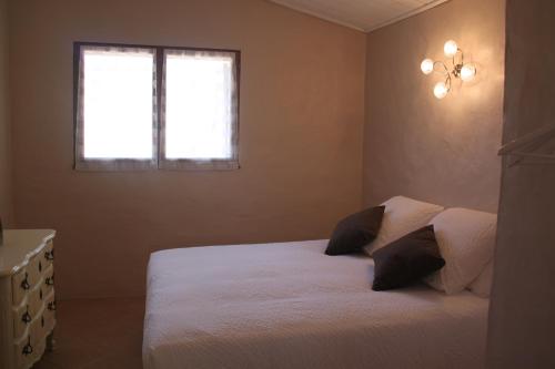 une chambre avec un lit blanc et une fenêtre dans l'établissement Gîte Pèbre d'aï avec Piscine Partagée, à Gordes
