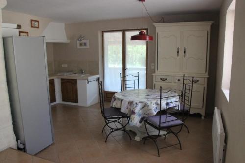 une cuisine et une salle à manger avec une table et des chaises dans l'établissement Gîte Pèbre d'aï avec Piscine Partagée, à Gordes
