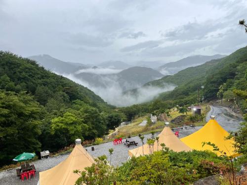 a view of a valley with tents and a river at Gurye Junsung Resort in Gurye
