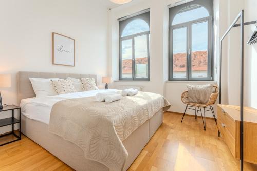 a bedroom with a large bed and two windows at Hakuna Cozy-Living city Center - free parking in Graz