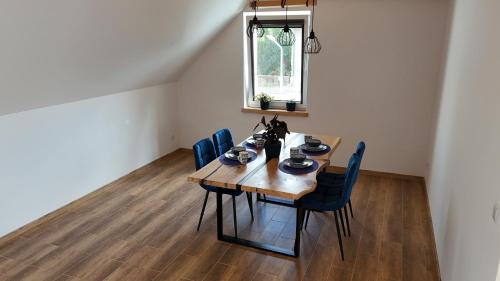 mesa de comedor con sillas azules y ventana en Apartament Podgórzyn, en Podgórzyn