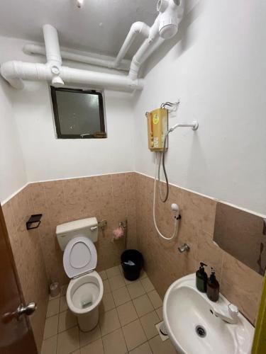 a bathroom with a toilet and a sink at Peaceful Pines 4 ROOMS FULL AC & NETFLIX by EZYROOM MELAKA in Ayer Keroh