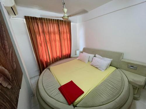 a small bedroom with a bed with a red book on it at Peaceful Pines 4 ROOMS FULL AC & NETFLIX by EZYROOM MELAKA in Ayer Keroh