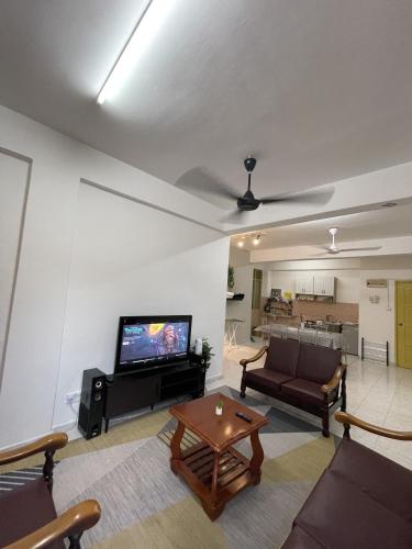 a living room with a tv and a couch and a table at Peaceful Pines 4 ROOMS FULL AC & NETFLIX by EZYROOM MELAKA in Ayer Keroh