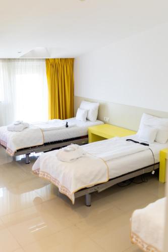 a room with three beds and a window at Christina Hotel in Bucharest