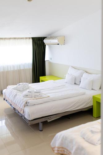 a hotel room with two beds and a window at Christina Hotel in Bucharest