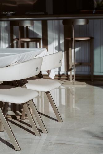 a white table and chairs in a room at Naos Luxury Hotel in Vlorë
