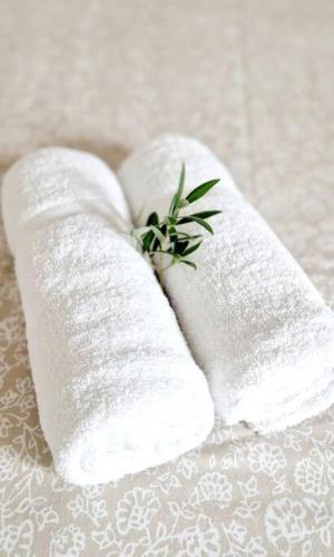 une paire de serviettes blanches avec une plante en elles dans l'établissement Maison Famille Proche Paris, à Margny-lès-Compiègne