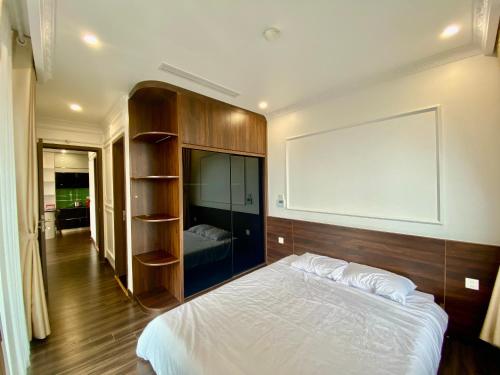 a bedroom with a large white bed and a board on the wall at LeeVy Hai Phong in Hai Phong