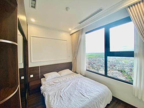 a bedroom with a bed and a large window at LeeVy Hai Phong in Hai Phong
