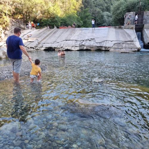 a man and a child standing in the water at Tre metr sopra il cielo '' GiraSoli'' in Felitto