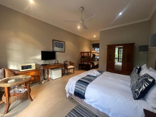 a bedroom with a bed and a living room at Sir Roys Guest House in Port Elizabeth