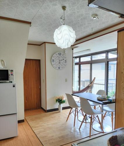 a kitchen and dining room with a table and a clock at JOY HOUSE Near Ikebukuro in Tokyo