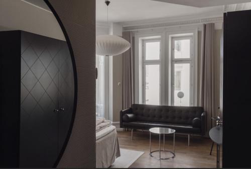 a living room with a black couch and a mirror at TwentySix in Malmö