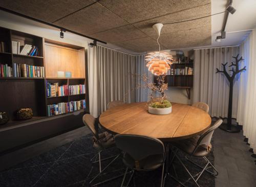 a dining room with a table and chairs and bookshelves at TwentySix in Malmö