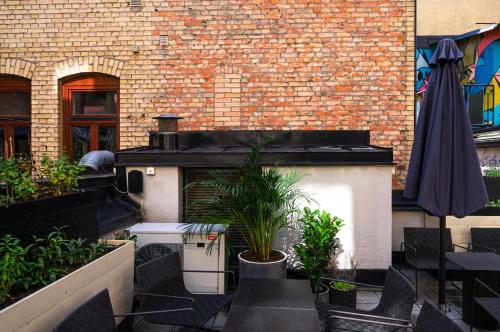 a patio with chairs and an umbrella next to a building at TwentySix in Malmö
