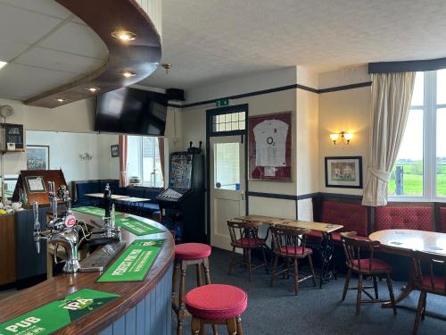 a bar in a restaurant with tables and chairs at The Netherend Inn - Pet Friendly Haven in Lydney