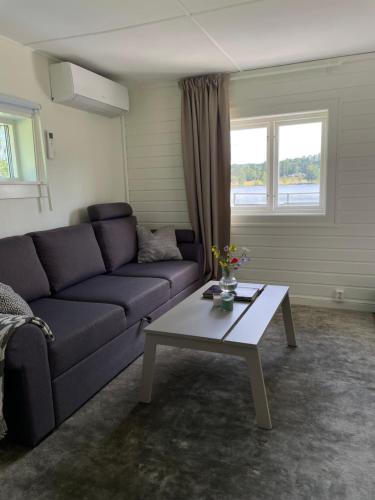 a living room with a couch and a coffee table at Stuga med strandtomt i Smålands natursköna miljö in Vaggeryd