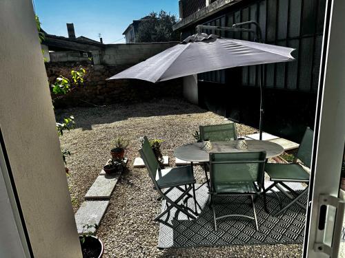 a table and chairs with an umbrella on a patio at Charmant T2 atypique proche du centre-ville in Miramas