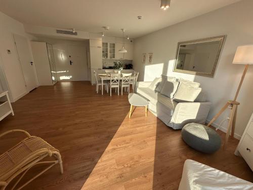 a living room with a white couch and a table at Pinea Apartments in Pobierowo