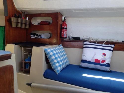 een bankje in een speelgoedbootje met een kussen bij Voilier NEVEN in Lorient
