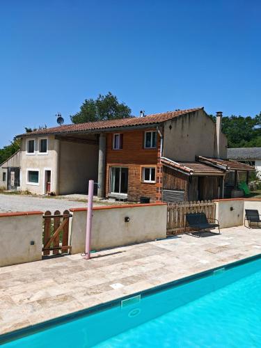 une maison et une piscine devant une maison dans l'établissement Terres de Barréjat, à Cazals-des-Baylès
