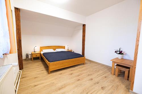 a bedroom with a bed and a wooden floor at Villa with a covered pool, park, and playground in Svoboda nad Úpou