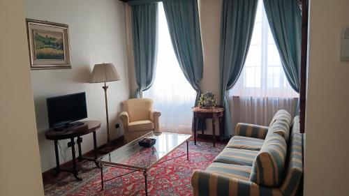 a living room with a couch and a tv at Palazzo Finati in Alba
