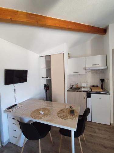 une cuisine avec une table et des chaises dans une pièce dans l'établissement studio en intramuros, à Avignon