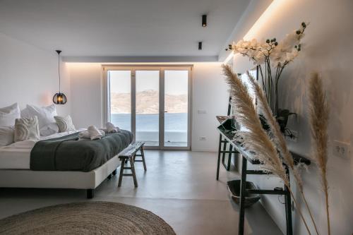 a bedroom with a bed and a view of the ocean at Villa Joy Mykonos Boutique Hotel in Ano Mera