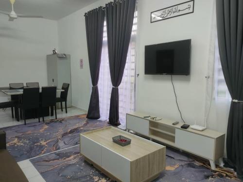 a living room with a tv and a table at Fatimah HomeStay Kulim Hi Tech in Kulim