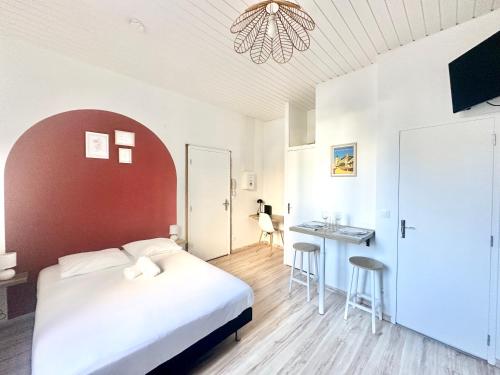 une chambre avec un lit blanc et un mur rouge dans l'établissement Le Victor, charmant et cosy, à Limoges