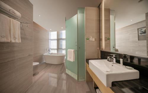a bathroom with a sink and a toilet and a tub at Grand Skylight International Hotel Ganzhou Chang Zhen Avenue in Ganzhou