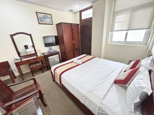 a bedroom with a bed and a chair and a mirror at Asia Hotel Can Tho in Can Tho