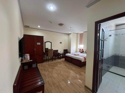 a bedroom with a bed and a bathroom with a shower at Asia Hotel Can Tho in Can Tho