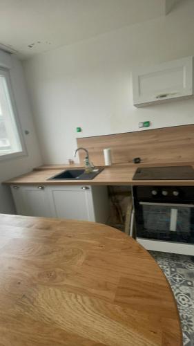 - une cuisine avec un comptoir en bois et une table en bois dans l'établissement Hennebont côté gare, à Hennebont