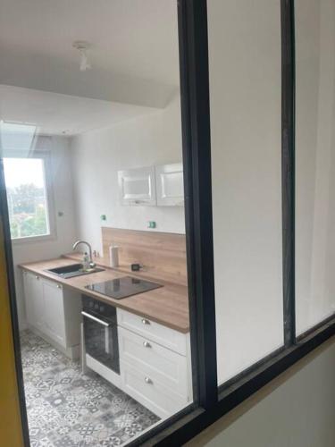 une cuisine avec un évier et une cuisinière dans l'établissement Hennebont côté gare, à Hennebont