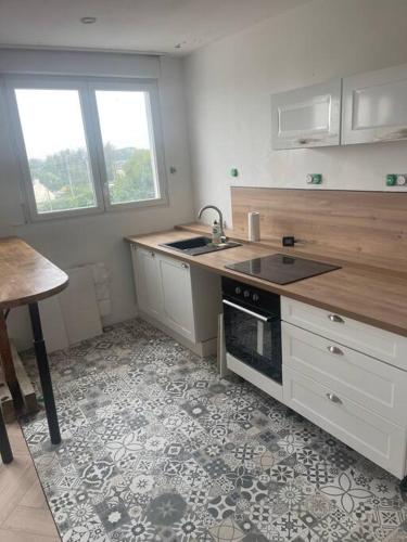 une cuisine avec un évier et une cuisinière dans l'établissement Hennebont côté gare, à Hennebont