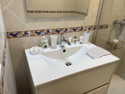 une salle de bain avec un lavabo blanc et un miroir dans l'établissement 2 pièces Saint Raphael rénové, classé 4 étoiles, 100 m plages, piscine, tennis, parc, terrasse, jardin privatif, à Saint-Raphaël