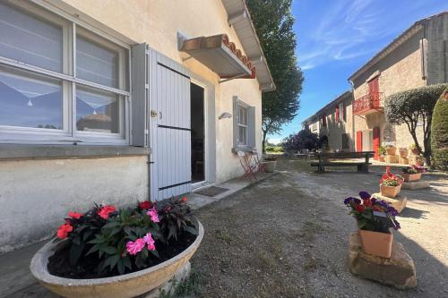 une maison avec deux pots de fleurs sur son côté dans l'établissement La Maison de Constance - Charmante Maison provençale 3 chambres, à Aigues-Mortes