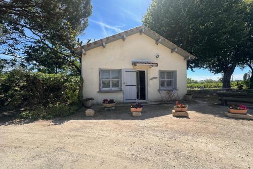 une petite maison blanche avec des plantes en pot devant elle dans l'établissement La Maison de Constance - Charmante Maison provençale 3 chambres, à Aigues-Mortes